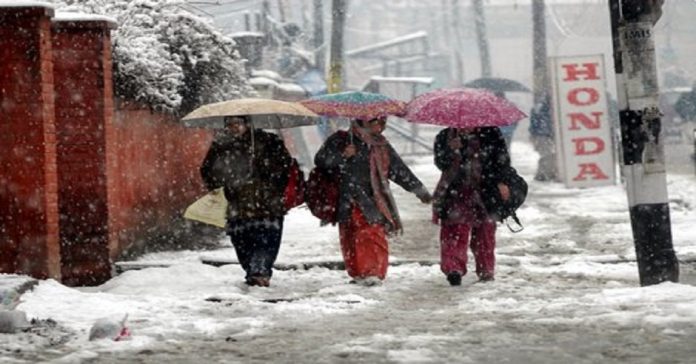 Kashmiri students walk amid snowfall