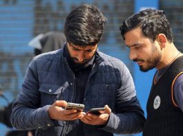 Youth accessing internet on their phones in Srinagar