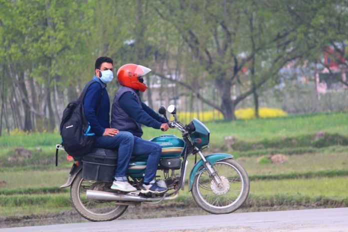 Pillion rider wearing mask in Pulwama in view of COVID-19