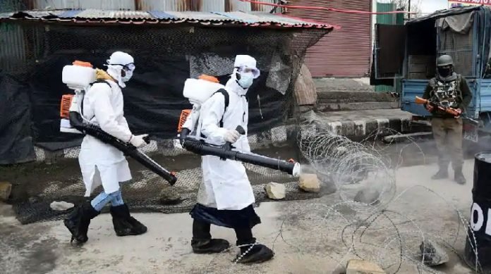 Srinagar Municipal Corporation (SMC) workers spray disinfectant