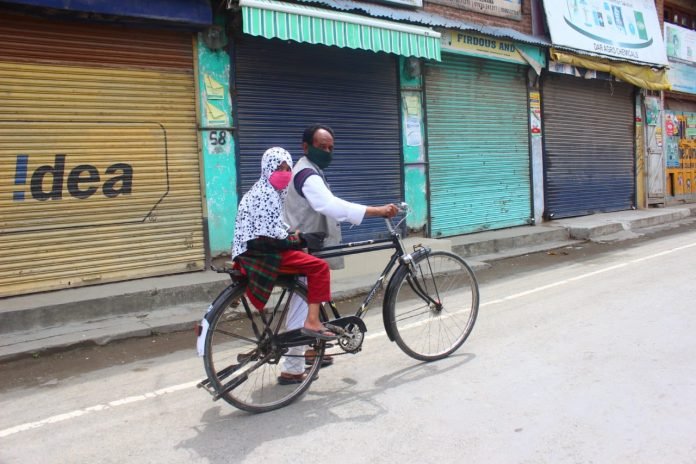 A man carries his daughter on his bicycle amid the Coronavirus-induced lockdown in Pulwama A man carries his daughter on his bicycle amid the Coronavirus-induced lockdown in Pulwama