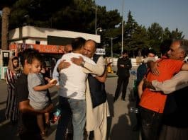 Families saying their goodbyes in the parking lot of the airport in Kabul