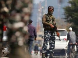 An Indian Army soldier stands guard on a Srinagar road