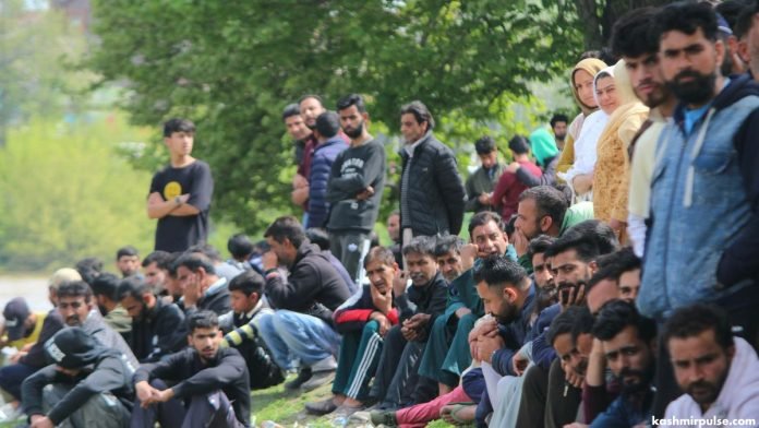 Bystanders look on as search efforts continue in Gandabal after boat capsize tragedy