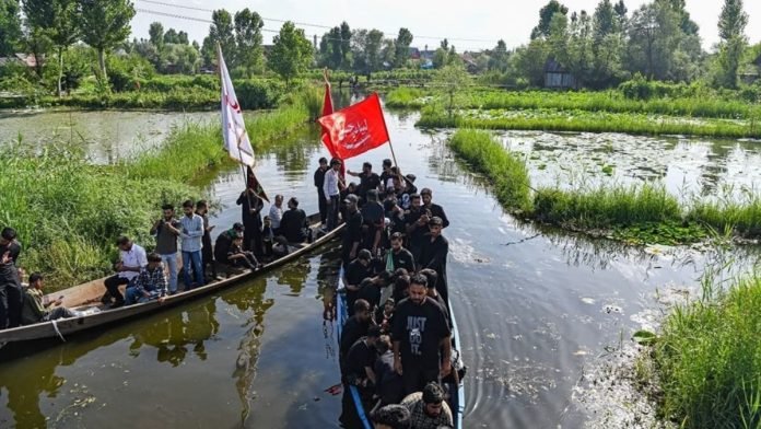 Shia mourners participate in a Muharram procession on boats in the interiors of Dal Lake in Srinagar