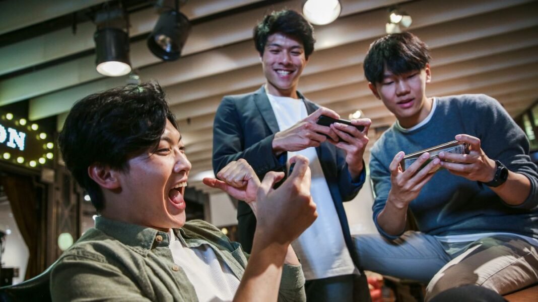 A group of youth playing real cash games on their mobile phones