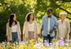 5 Surprising Benefits of Spending Time Outdoors for Your Mental Health Sunlight filters through lush green trees as a diverse group of people share genuine smiles and laughter while enjoying a walk amidst vibrant wildflowers in a park