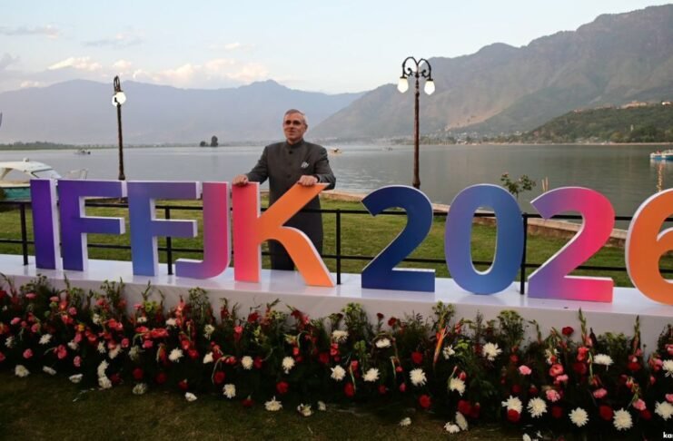 Omar Abdullah getting his photo clicked along IFFJK 2026 decorative board